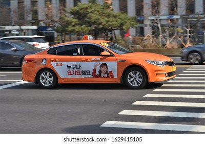 Seoul South Korea 24 January 2020: moving orange Seoul taxi with advertisement on its side