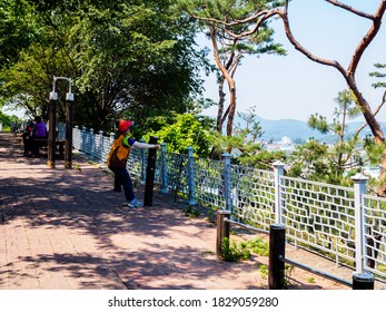 Seoul, South Korea - June 14, 2017: Older Korean Woman Doing Physical Exercise On The Sports Public Equipment In The Park In Seoul.