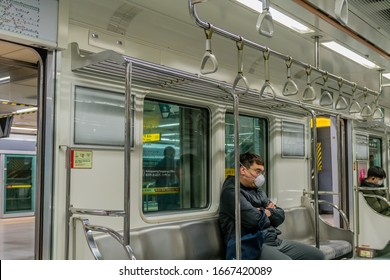 Seoul, South Korea; March 6, 2020: Unidentified man wearing face mask sitting alone in almost empty subway during COVID-19 outbreak.