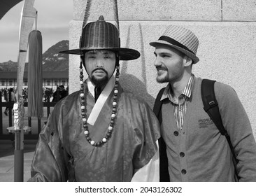 SEOUL, SOUTH KOREA - OCTOBER 22, 2013: Korean Man And European Tourist Standing Side By Side In Seoul Main Street