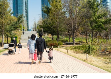 Seoul,South Korea-April 2020: Korean  Family Holding Hands With Their Daughter While Walking At Seoul Forest Park.