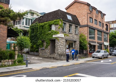 Seoul,South Korea-May 2021: People Walking In Front Of Modern Industrial Stone Building With Green Wall Plants In The Alley Way In Seoul, South Korea