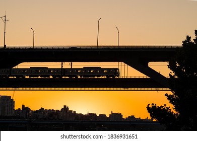 Seoul,South Korea-September 2020: Silhouette of Seoul subway train at the bridge with yellow sunset view