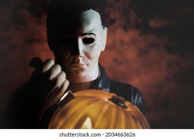 SEP 1 2021: Halloween slasher Michael Myers stabbing a jackolantern with a knife and bloody background - Spirit Halloween decoration