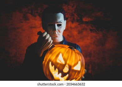 SEP 1 2021: Halloween slasher Michael Myers stabbing a jackolantern with a knife and bloody background - Spirit Halloween decoration