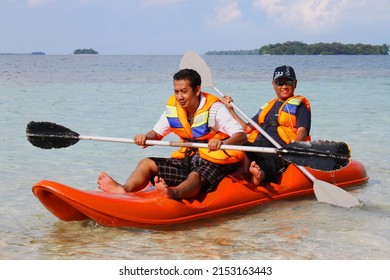 Sepa Island, Indonesia - May 3rd, 2014 : Two Men Are Rowing The Life Boat In The Sunny Beach While Spending The Holiday Time