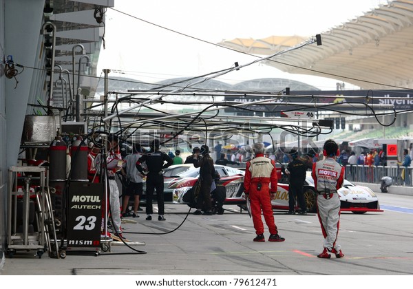 SEPANG - JUNE 19: Team mechanics working in the\
pitlane during the qualifying sessions of the Japan SUPER GT Round\
3 at the Sepang International Circuit on June 19, 2011 in Sepang,\
Malaysia.