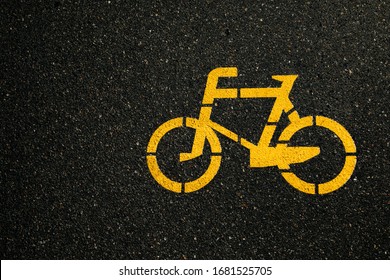 Separate bike path for cycling. Yellow painted bike on the pavement. Ride on an ecological green city transport.