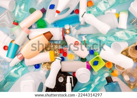 Separate collection of plastic garbage. PET, PP, HDPE, LDPE stuff for recycle on blue background. Eco friendly concept. Recyclable plastic waste:  bottles, containers, disposable cups, bottle caps