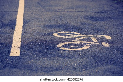 Separate lane for cycling in a park. White symbol of bicycle and straight line showing the direction of traffic. No models - Shutterstock ID 420682276