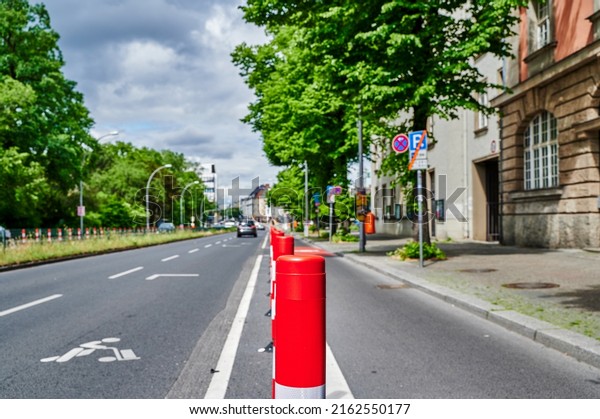 Separated bike lane on a main\
street in Berlin to improve road safety at the expense of parking\
lane.