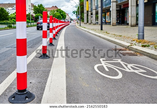 Separated bike lane on a main\
street in Berlin to improve road safety at the expense of parking\
lane.