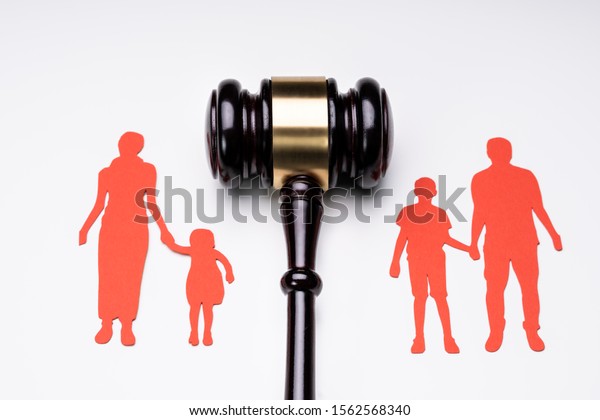 Separated Family Figure Paper Cutout And Judge\
Gavel Over White\
Surface
