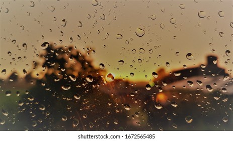 Separated raindrops on a window in front of the setting sun (closeup) HQ