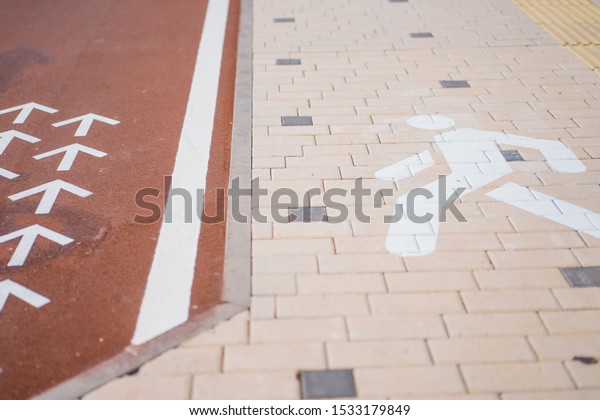 separation of the pedestrian area and the bicycle\
path. A bike path and a pedestrian street, and bicycle racks in a\
pedestrian area with many bicycles parked. signs for cycle and\
pedestrian paths.