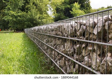 Separation of the street from the park area. A fragment of a fence made of gabions. 