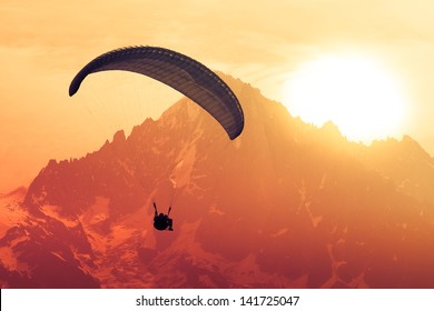 Sepia paraglide silhouette over Alps peaks