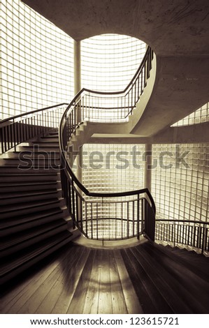 Sepia tone spiral staircase surrounded by mirror