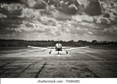 Sepia Toned Propeller Aircraft Taking Off Into Turbulent Looking Clouds