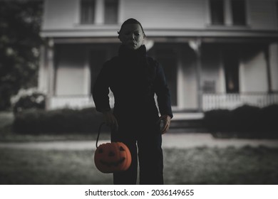 SEPT 3 2021: Halloween slasher Micheal Myers with a trick or treat pumpkin pail outside the Myers house in Haddonfield  - Neca action figure