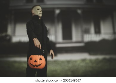 SEPT 3 2021: Halloween slasher Micheal Myers with a trick or treat pumpkin pail outside the Myers house in Haddonfield  - Neca action figure
