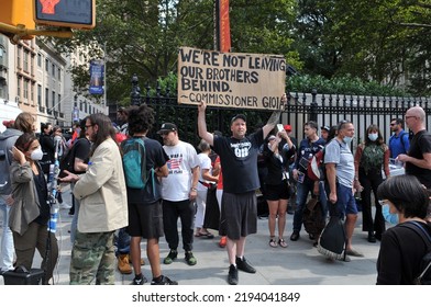 September 11 2021: Man In Gym Shorts And Black Tee Shirt Holding Up Sign To Protest With Crowd Of People In Background Across The Street At The World Trade Center On 9 11 2021. 