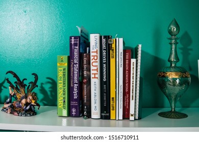 September 20, 2019 Cumberland Rhode Island USA. Book Shelf Educational And Self Help Book Stack Collection. Fairy And Weights Decorating Shelf.