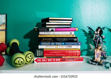 September 20, 2019 Cumberland Rhode Island USA. Book Shelf Educational And Self Help Book Stack Collection. Fairy And Weights Decorating Shelf.