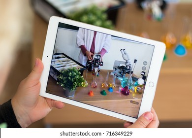 September, 2017 - Belarus, Minsk. Teacher in the chemistry class makes photo on Ipad Apple of the Lego robot. Experiments with the robot. Tablets. Stem education. Microscope and tubes.