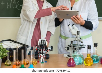 September, 2017 - Belarus, Minsk. Women Teacher And Teenager Student Are In Chemistry Class. Tey Make Test. STEM Education. Lego Mindstorm Robot, Mechanic, Chemistry, Biology. They Use Apple Ipad.