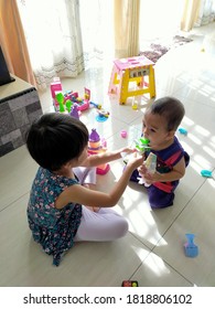 September 2020, Selangor, Malaysia. An Adorable Act Of Sharing. Two Siblings Sharing Ice Cream After Making Mess With The Toys.