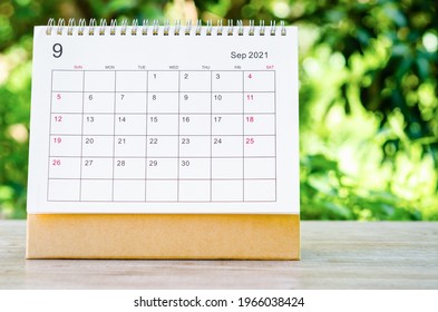 September 2021 Calendar desk for organizer to plan and reminder on wooden table on nature background.