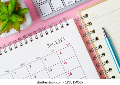 September 2021 calendar with note book on pink background.