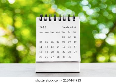 September 2022
 desk calendar for planners and reminders on a black table on the natural background green .