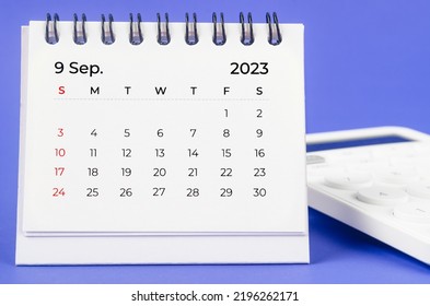 September 2023 Monthly desk calendar for 2023 year with calculator on purple background.