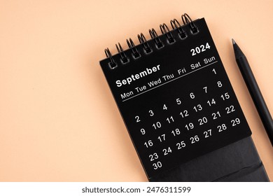 September 2024 Black spiral desktop calendar and wooden pencil on yellow color background. - Powered by Shutterstock