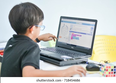 September, 207. Phil the young boy is coding his program in his digital classroom in Thailand.