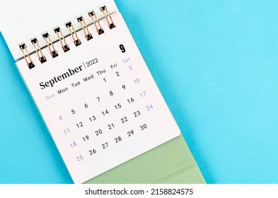 The September desk calendar 2022 on blue background.