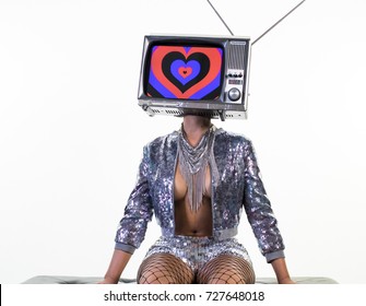 sequence of amazing woman sitting and posing with a television as a head. the tv has an image of hearts on it.