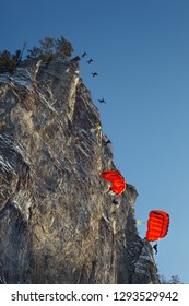 Sequence of BASE jump from a high cliff, bottom view.
