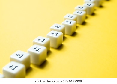 Sequential chain of blocks with plus one. Sequence. Arithmetic progression. Add one more. Increase and growth. A series concept. Accumulation process. Continuation. Sequential addition to the sum.