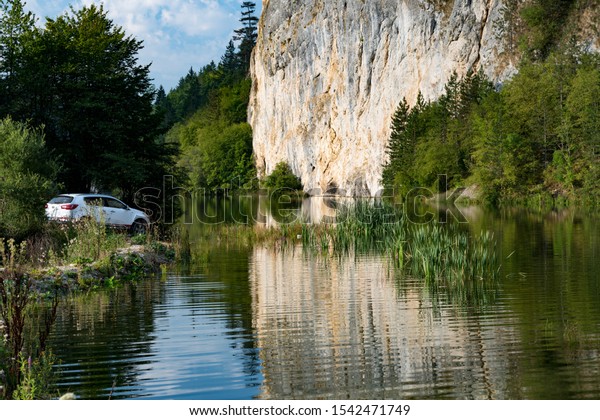 Serbia - 09.21.2018 / car Kia Sportage 2.0 CRDI awd\
or 4x4, white color,  crossing a lake Lazici, on mountain Tara,\
near a big cliff, and beautifull countryside, in deep mud wheel\
spin, great off road