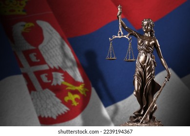 Serbia flag with statue of lady justice and judicial scales in dark room. Concept of judgement and punishment, background for jury topics