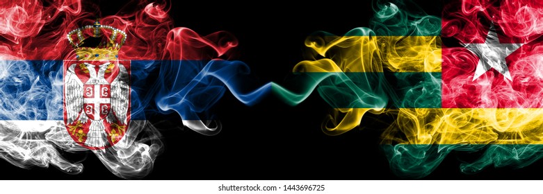 Serbia vs Togo, Togolese smoky mystic flags placed side by side. Thick colored silky smokes combination of Serbian and Togo, Togolese flag
