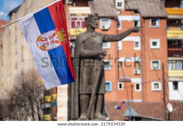 Serbian flag infront of Prince Lazar\
Hrebljanovic of Serbia statue monument in the Serbian northern part\
of the divided city of Kosovska Mitrovica. North Kosovska\
Mitrovica, Kosovo, Serbia\
04.03.2022