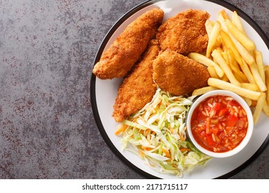 Serbian Fried Chicken With French Fries, Cabbage Salad And Hot Sauce Close Up In The Plate On The Table. Horizontal Top View From Above
