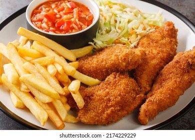 Serbian Fried Chicken With French Fries, Cabbage Salad And Hot Sauce Close Up In The Plate On The Table. Horizontal
