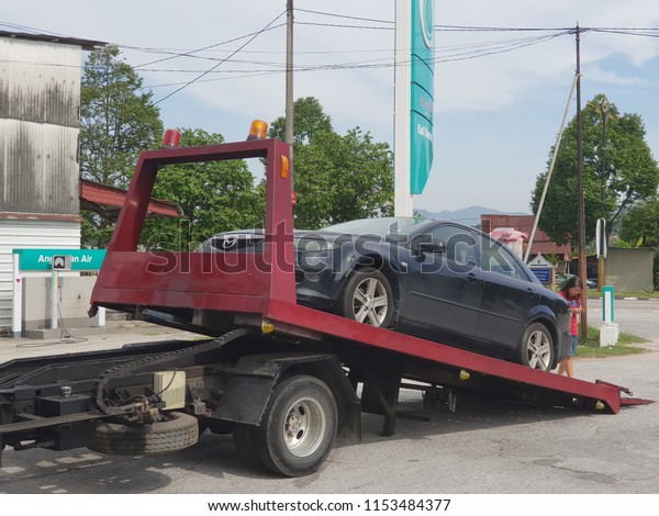 Seremban, Malaysia - 10/8/2018 : A car broke down\
and being towed by a tow\
truck