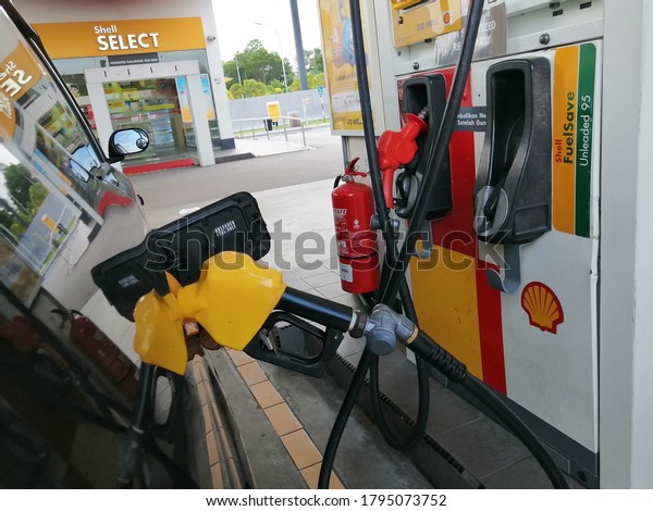 Seremban, Malaysia. Aug 13 2020:\
Fuel nozzle add\
a fuel car petrol at Shell petrol station. Image may contain noise\
or grain.
