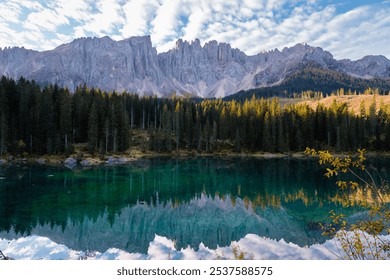 A serene alpine lake reflects the towering Dolomite mountains, surrounded by lush evergreen forests under a vivid sky. Lake Carezza or Karersee Dolomites in Italy. - Powered by Shutterstock